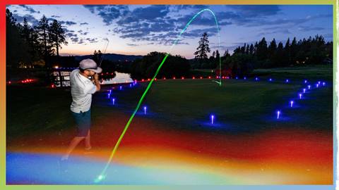A golfer swinging his club with ball mid flight during Glow Golf at Bear Mountain Golf Course