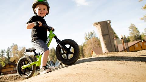 Young child on a stride bike at snow summit in the summer
