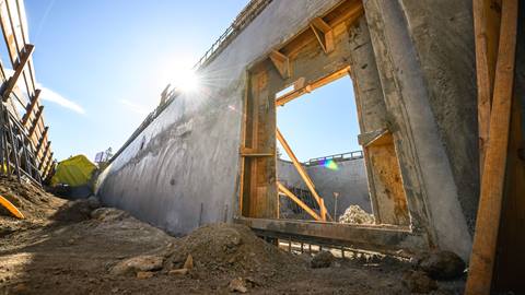 Wooden structural walls being plastered with concrete.
