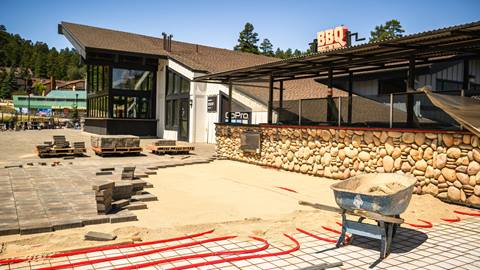 Pavers being laid out in front of outdoor restaurant.