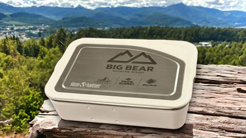 Klean Kanteen Big Bear Mountain Resort meal box on a log with a beautiful green mountain background with clouds