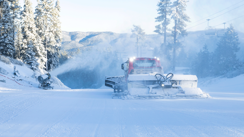 active snowmaking on a ski slope at big bear mountain resort with a grooming cat machine