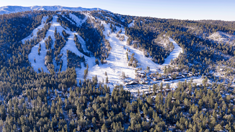 Drone shot from a far view of big bear mountain resort freshly covered in snow