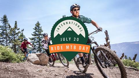 international MTB day logo over 3 mountain bikers on a sunny day