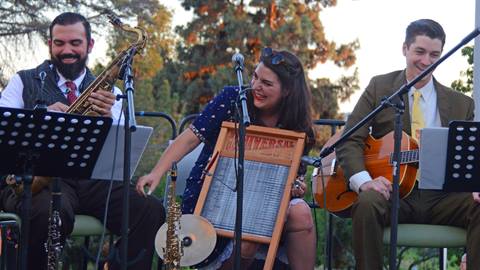 A three piece jazz band playing their instruments on stage.