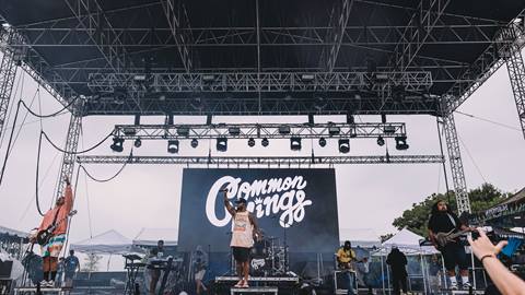 The Common Kings band performing on stage with a black and white graphic band name backdrop.