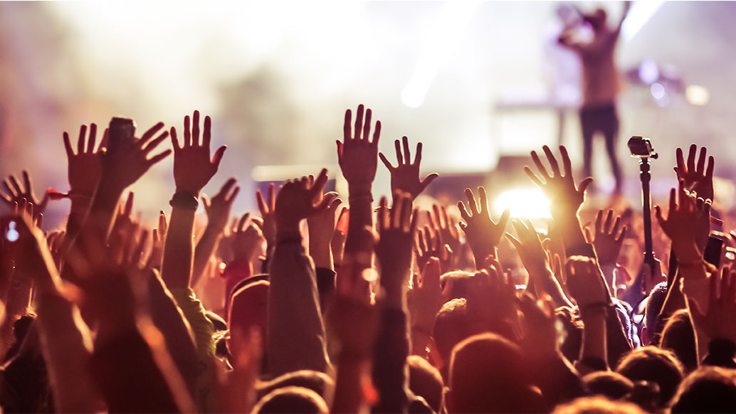 crowds hands raised at a concert