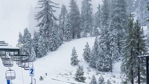 Snow Valley drone image above a chairlift capturing new snowfall layered on the slopes and trees.