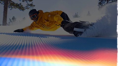 Snowboarder carving on corduroy snow