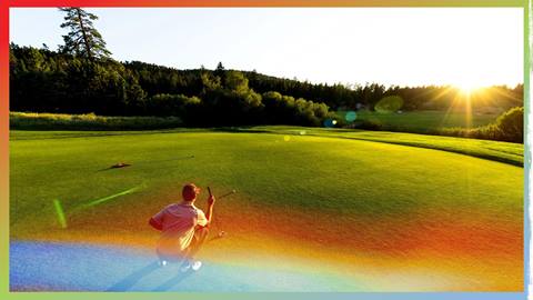 A golfer looking at his ball line to the flag pin