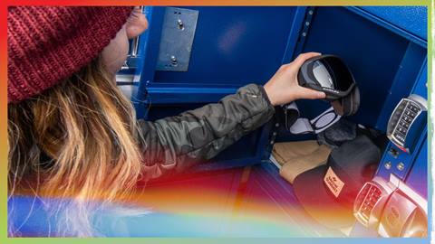 Adult in red beanie putting items into a rental locker