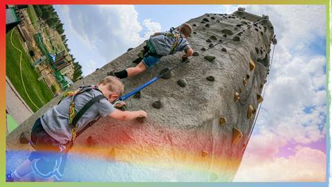 Two kids climbing the rock wall at Snow Summit