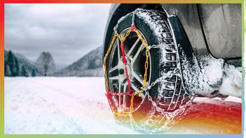Close up of a tire with snow chains on the front left tire
