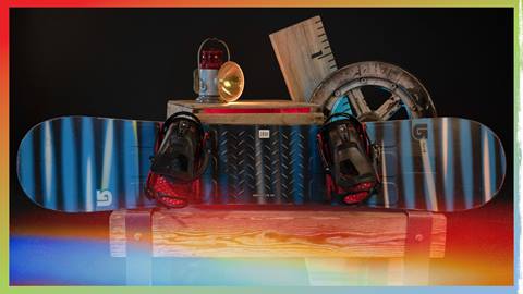 Snowboard with bindings leaning against a wooden box