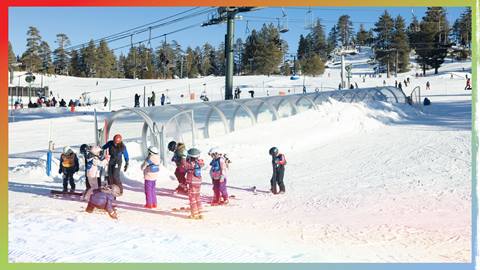 Bunch of kids standing on the snow waiting for their lesson