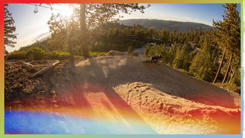 A mountain biker at Snow Valley during a Twilight Session riding through a berm