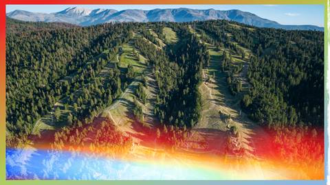 Ariel view of Snow Summit during the summer with green forestry and trails going downhill.