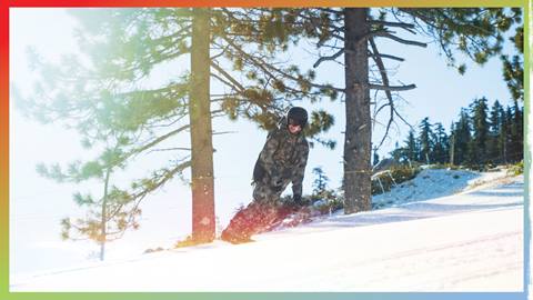 Snowboarder in military uniform hitting the slopes on a sunny day