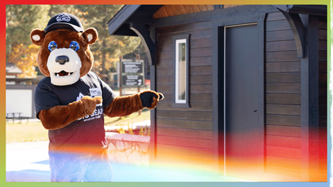 Biggie the mascot standing in front of his shack