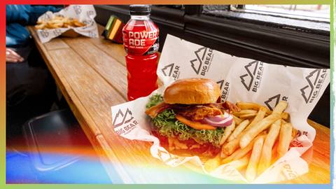 A BBMR burger with french fry basket and red Powerade drink on a tabletop.