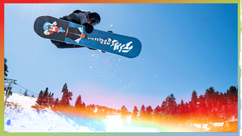 Snowboarder in the air grabbing his board