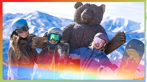 A group of female skiers and snowboarders posing together on a snowy trail at Big Bear Mountain Resort.
