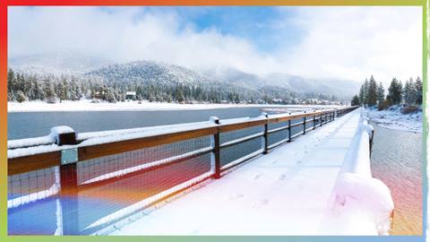 Fresh snow on a fence and walking path along Big Bear Lake