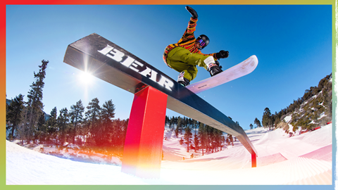 snowboarder on a black bear mountain rail doing a trick