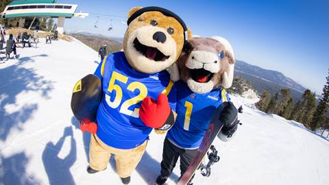 Biggie the Bear and Rampage mascot posing for a photo at the top of Chair 9 at bear mountain in the winter