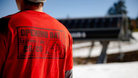 Adult wearing a Bear Mountain red 25/26 winter season opening day t-shirt.