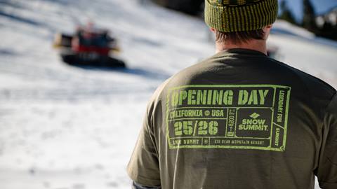 Adult wearing a Snow Summit green 25/26 winter season opening day t-shirt.