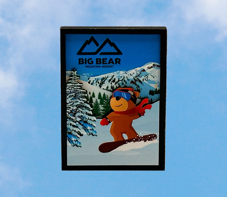 Big bear mountain resort wooden magnet with biggie the bear snowboarding with mountains snow and trees in background.