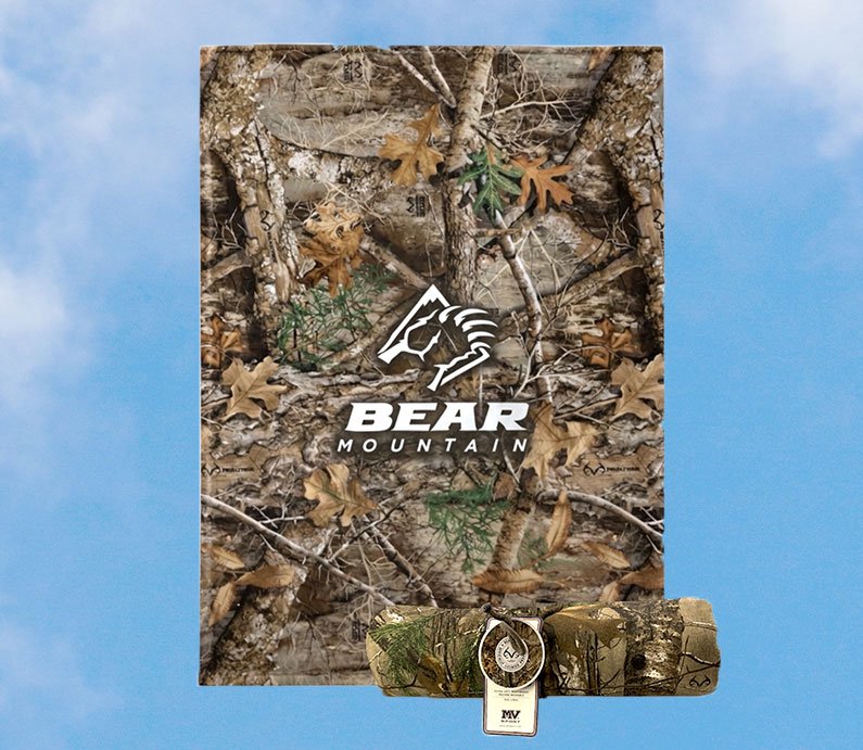 Camouflage woods patterned sweatshirt blanket with Bear Mountain logo in white.