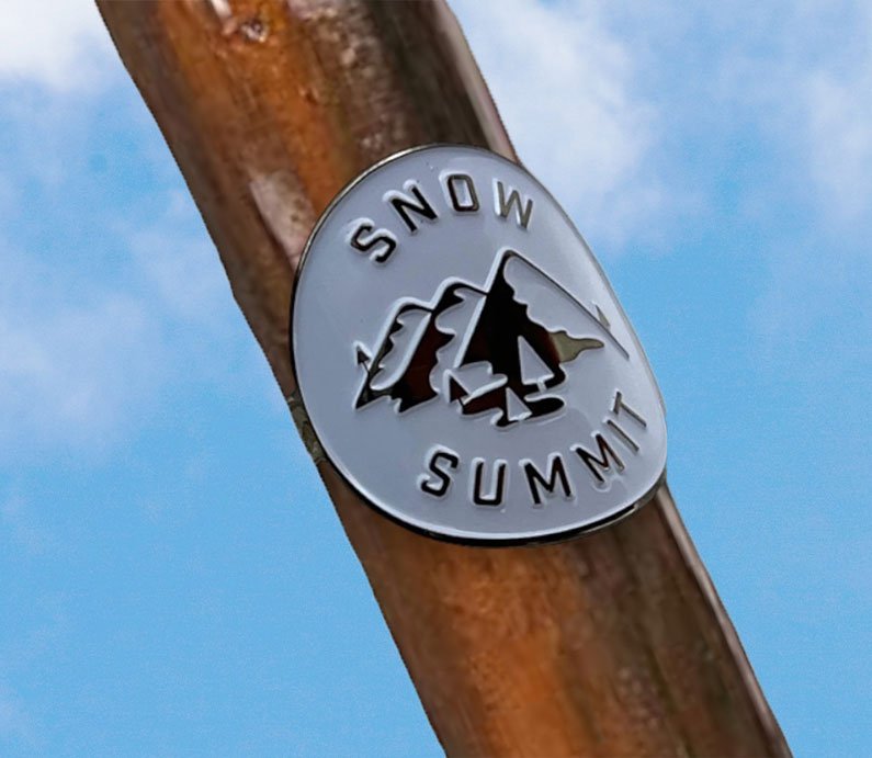 Metal medallion with two screws and a snow summit logo on it.