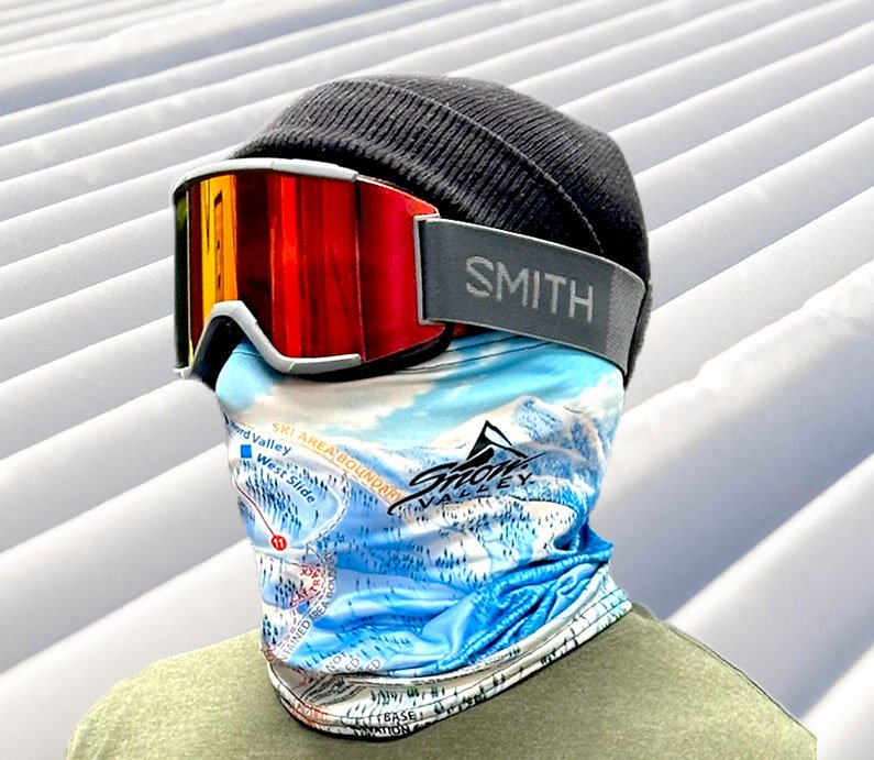 Rider in black beanie, Smith goggles, and a Snow Valley winter trail map neck gaiter.