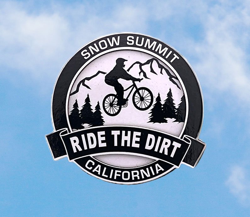 Black and white magnet with biker, alpine trees, and mountain landscape and the word "Ride the Dirt California" on the lower half.
