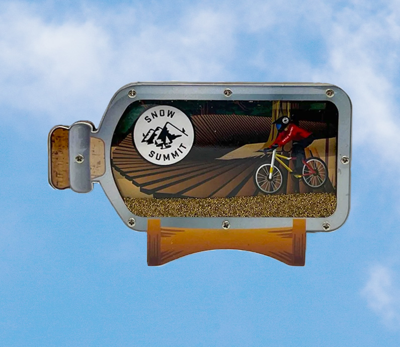 A Snow Summit summer inspired biker in a bottle magnet with a mountain biker riding a dirt trail.