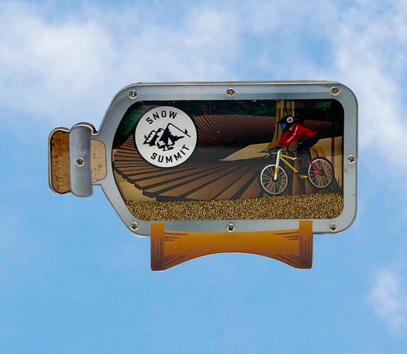 A magnet with a mountain biker in a bottle.