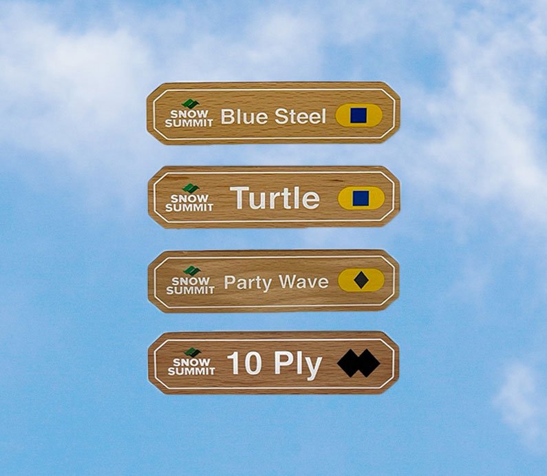 Wooden magnets with a Snow Summit logo on the left and trail signs for: Blue Steel, Turtle, Party Wave, and 10 Ply copy on it with difficulty legend rating