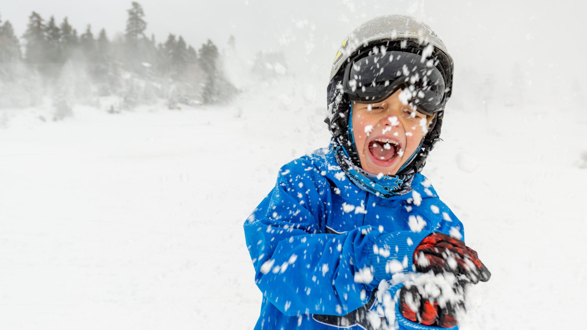 Kid in the snow when it is snowing