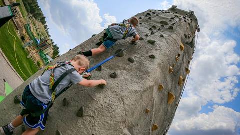 two kids climbing the rock wall