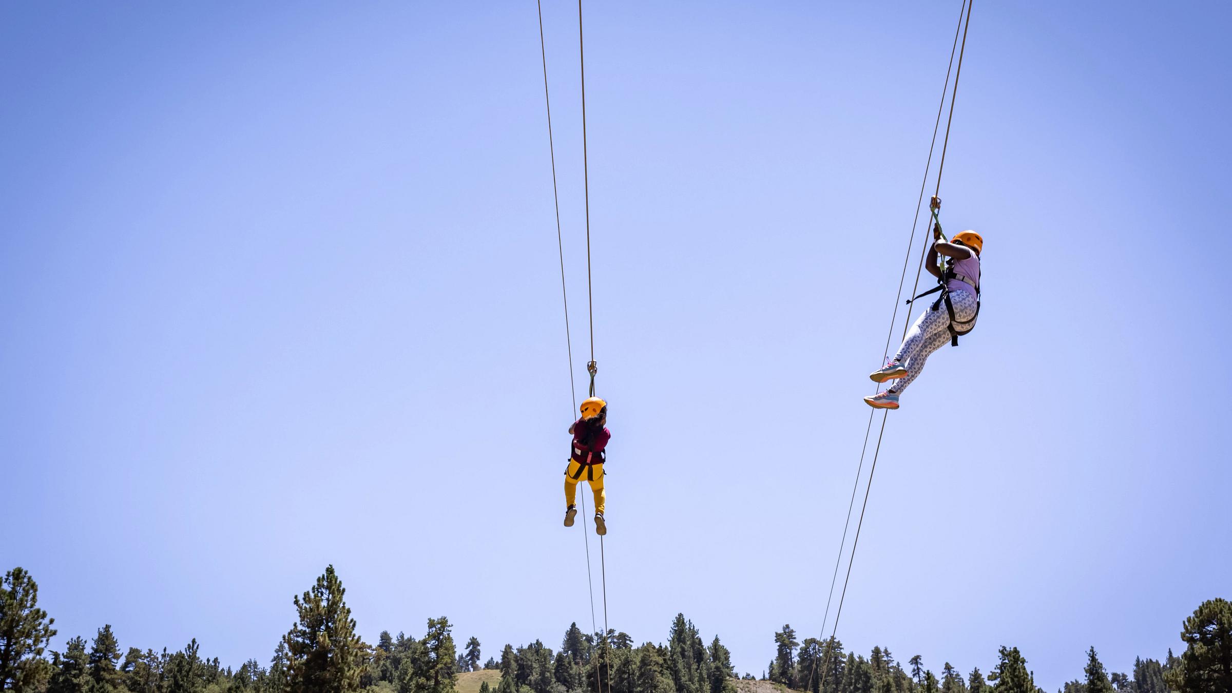 Two kids riding the zipline