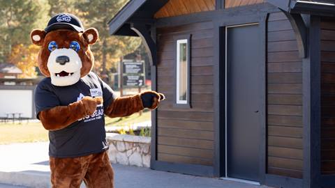 Biggie the mascot standing in front of his shack