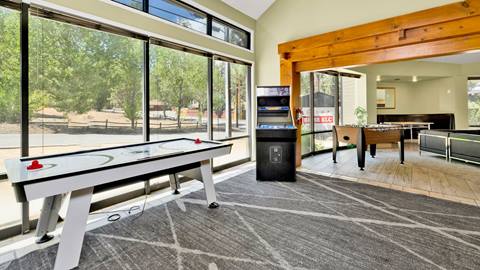 Inside common area of an employee housing building that has a video arcade game, air hockey, foosball, and a lounge area.