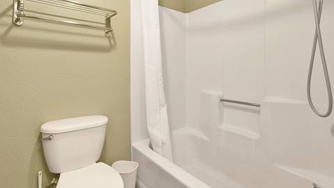 Bathroom with toilet next to a shower tub combo