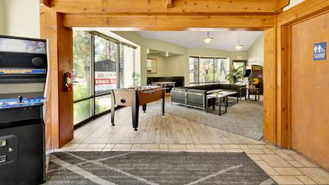 Inside common area of an employee housing building that has a video arcade game, foosball, and a lounge area.