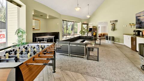 The inside area of an employee housing building that has a foosball table and a lounge area with couches.