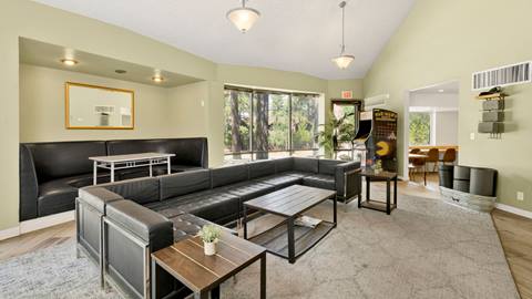 The inside area of an employee housing building that has a big lounge area with couches and coffee tables.