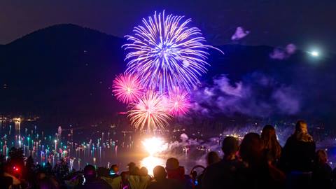 Mesmerized attendees of Snow Summit's Above the Boom event watching colorful and vibrant fireworks explode in the night sky above Big Bear Lake.