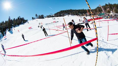 Bear Bowl participant holding a football running through the relay race course.